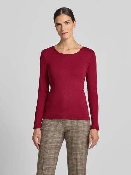 Frauenmodel trägt Slim Fit Longsleeve aus reiner Baumwolle von Christian Berg Woman in Rot, Rundhalsausschnitt, tailliert, Nahaufnahme Oberkörper.