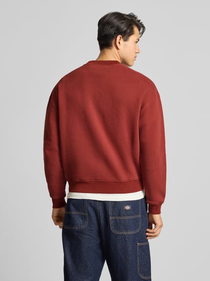 Männermodel trägt Sweatshirt mit Logo und Rundhalsausschnitt von BLKVIS in Dunkelrot, reine Baumwolle, Relaxed Fit, Ganzkörperansicht Rückansicht.