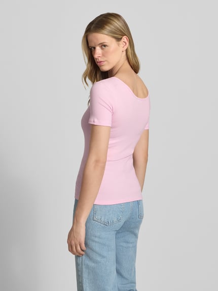 Frauenmodel trägt rosa Slim Fit T-Shirt aus Baumwoll-Mix Modell 'KITTE' von Pieces, Damen T-Shirt, dezente Struktur, Ganzkörperansicht Rückansicht.