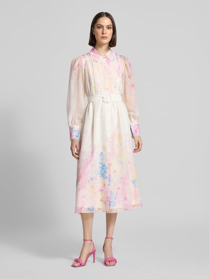 Vrouwenmodel draagt midi-jurk uit lyocellmix model 'Florence' van YAS met platte kraag, getailleerd, bloemenprint, knoopsluiting, riem, met lange mouwen, all-over print, ruglengte 123 cm, borstwijdte 47 cm, mouwlengte 65 cm, pastelkleuren, vloeiende stof, voorkant gezichtsopname, geheel zichtbaar.
