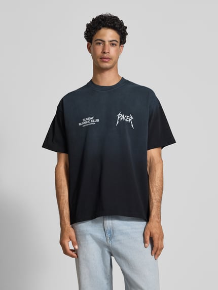 Männermodel trägt schwarzes T-Shirt mit weißem Statement-Print, Boxy Fit, reine Baumwolle, SRC® Pacer von ANOTHER COTTON LAB, Nahaufnahme Oberkörper
