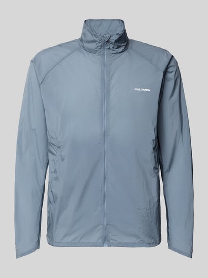 Produktfoto, Jacke mit Logo und Eingrifftaschen von Salomon in Blau mit krój regular fit, stójka, zamek błyskawiczny, długość tyłu w rozmiarze M: 70 cm, szerokość ramion w rozmiarze M: 43 cm, szerokość klatki piersiowej w rozmiarze M: 35 cm, długość rękawów w rozmiarze M: 67 cm