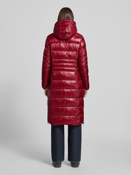 Frauenmodel trägt glänzend roten, unifarbenen Longline Puffer Coat mit Kapuze, Logo-Patch und Reißverschlusstaschen, Puffer Coat mit Kapuze Modell 'DALIA LONG' von FRIEDA & FREDDIES, Ganzkörperansicht Rückansicht.