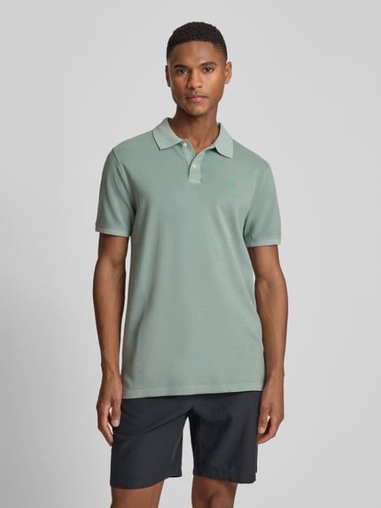 Männermodel trägt Slim Fit Poloshirt mit Label-Stitching von GAP in Mintgrün, Baumwoll-Elasthan-Mix, Knopfleiste, Ganzkörperansicht von vorne.