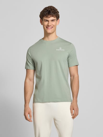 Männermodel trägt Regular Fit T-Shirt mit Logo-Print von SERGIO TACCHINI in Mintgrün aus reiner Baumwolle, Nahaufnahme Oberkörper.