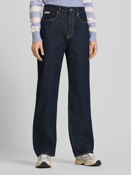 Kobiece model prezentuje Straight Fit Jeans mit Label-Detail od Calvin Klein Jeans z bawełny, kolor ciemnoniebieski, Ganzkörperansicht von vorne. Szerokość w pasie: 37 cm, długość wewnętrzna nogawki: 80 cm, model THE STRAIGHT BOOT RESIN.