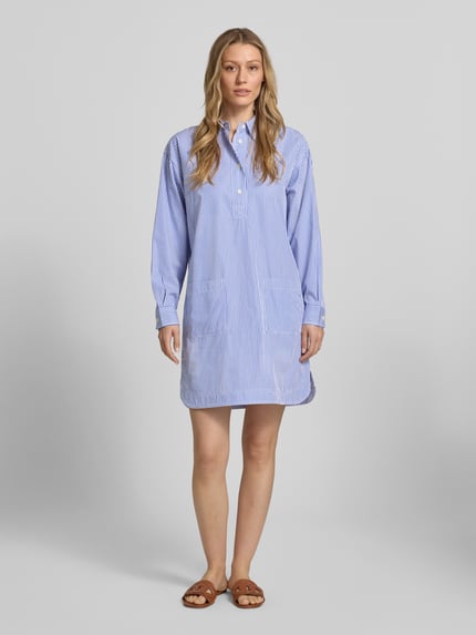 Frauenmodel trägt Oversized Hemdblusenkleid aus reiner Baumwolle von Lauren Ralph Lauren mit blau-weißem Streifenmuster, Mini-Länge, Knopfleiste, langen Ärmeln und Twillstruktur, Ganzkörperansicht von vorne.