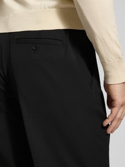 Männermodel trägt Regular Fit Chino mit Viskose-Anteil von Selected Homme, czarny, materiał: mieszanka z dodatkiem wiskozy, wpuszczane i tylna kieszeń, splot twill, krój regular fit, szlufki na pasek, zapięcie na guzik i zamek błyskawiczny, elastyczny pas, efekt: jednolity kolor, Ganzkörperansicht Rückansicht.
