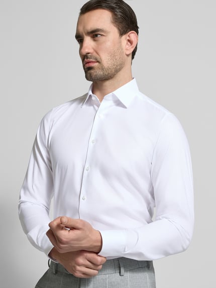 Männermodel trägt Slim Fit Business-Hemd mit Strukturmuster und Kentkragen von OLYMP Level Five im Unifarbenes-Design, Nahaufnahme Oberkörper. Baumwoll-Mix mit Stretch-Anteil, Herren Business-Hemd, Rückenlänge 80 cm, Schulterbreite 41 cm, Ärmellänge 66 cm.