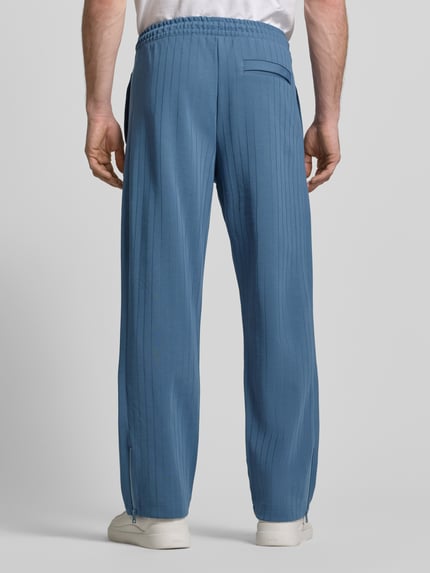 Männermodel trägt Regular Fit Sweatpants aus Baumwoll-Mix Modell 'DAVROPANT' von HUGO, Optik: Unifarben, gestreift, Ganzkörperansicht Rückansicht.