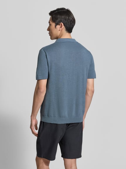 Männermodel trägt Regular Fit Poloshirt aus Baumwoll-Leinen-Mix Modell 'MATTIS' von SELECTED HOMME in Blau, kurzarm, unifarben, Feinstrick, Ganzkörperansicht Rückansicht.