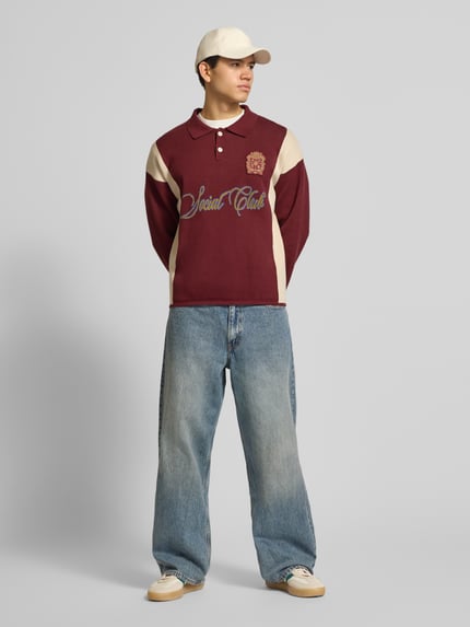 Männermodel trägt Strickpullover mit Polokragen und Label-Patch von PROHIBITED in Reine Baumwolle, Relaxed-Fit, Ganzkörperansicht von vorne.