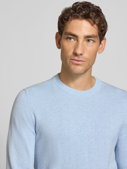Männermodel trägt Strickpullover aus Baumwoll-Kaschmir-Mix mit Rundhalsausschnitt von MCNEAL in Hellblau, Nahaufnahme Oberkörper. Regular Fit, Rückenlänge 70 cm, Ärmellänge 74 cm.