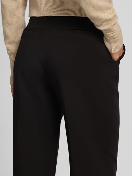 Frauenmodel trägt Straight Fit Hose mit Eingrifftaschen von Christian Berg Woman in dunkler Farbe, strukturierte Oberfläche, Nahaufnahme Gesäß. Mix mit Viskose-Anteil, Paspeltaschen am Gesäß, Bundweite 38 cm, Innenbeinlänge 78 cm.