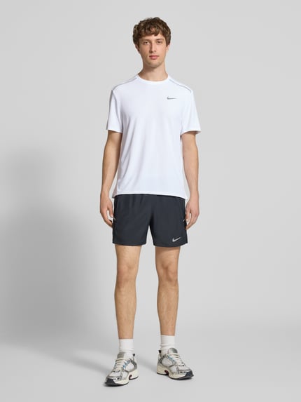 Männermodel trägt T-Shirt mit Rundhalsausschnitt und Logo von NIKE TRAINING, Regular-Fit, Kontraststreifen, Rückenlänge 74 cm, Ganzkörperansicht von vorne.