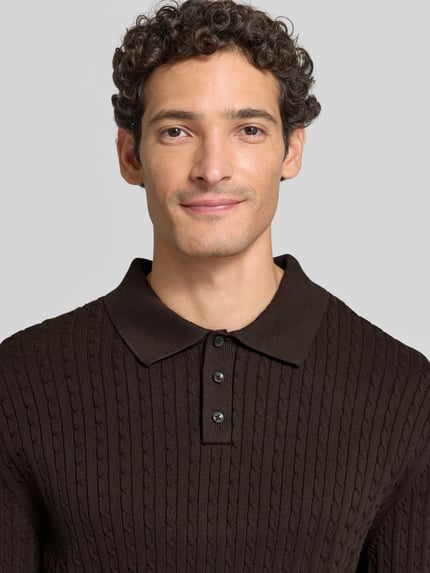 Męski model nosi Strickpullover mit Polokragen und kurzer Knopfleiste von MCNEAL, brązowy, czysta bawełna, krój regular fit, wzór w splot warkoczowy, żebrowane wykończenia, zbliżenie na górę ciała.