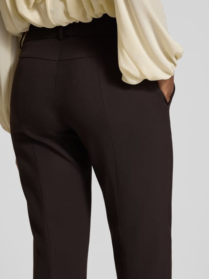 Frauenmodel trägt Regular Fit Hose Modell 'SARAH' von CAMBIO in Unifarbe matt, mit Bundfalte, Bügelfalten, Gürtelschlaufen, Detailaufnahme.