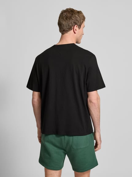 Männermodel trägt Regular Fit T-Shirt aus reiner Baumwolle von Tommy Jeans, Optik: Unifarben, Ganzkörperansicht Rückansicht.
