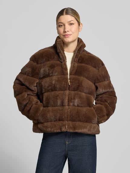 Modelka nosi Regular Fit Jacke aus Kunstfell od PETITE M., brązowe sztuczne futro, pikowanie, stójka, zamek błyskawiczny, długość tyłu w rozmiarze 36: 57 cm, szerokość ramion w rozmiarze 36: 42 cm, szerokość klatki piersiowej w rozmiarze 36: 56 cm, długość rękawów w rozmiarze 36: 57 cm, widok całej sylwetki z przodu.