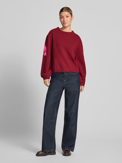 Frauenmodel trägt Strickpullover aus Wolle mit Stitchings und Perlen von Christian Berg Woman in Dunkelrot, relaxed Fit, Ganzkörperansicht von vorne.