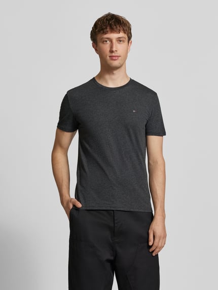 Mannelijk model draagt Slim Fit T-Shirt uit katoenmix model 'JASPE HERITAGE' van Tommy Jeans, melange look, logo-stiksel, korte mouwen, voorkant volledige lichaamsweergave.
