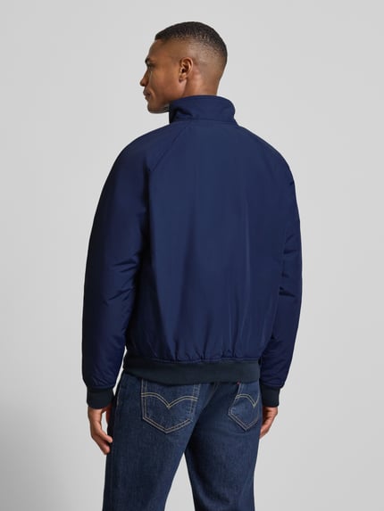 Męski model nosi Kurtkę z stójką i zamkiem błyskawicznym od Polo Ralph Lauren, mieszanka bawełny, krój regular fit, widok całej sylwetki z tyłu.