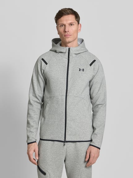 Męski model nosi Regular Fit Jacke mit Kapuze Modell 'Unstoppable' od Under Armour, jasnoszary kolor, logo, zamek, krój regular fit, całość z przodu
