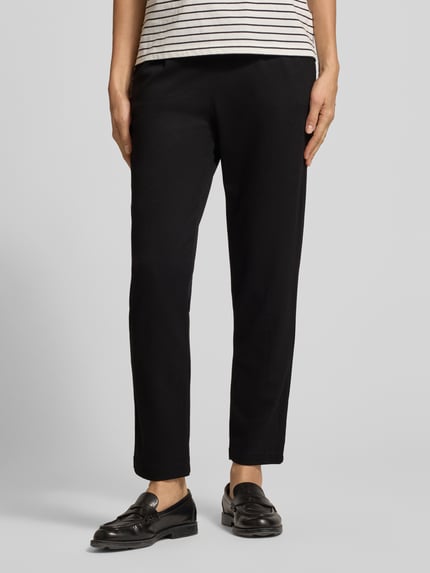 Frauenmodel trägt Hose aus Viskose-Mix mit elastischem Bund und Tunnelzug von Christian Berg Woman, schwarze Farbe, Regular Fit, Nahaufnahme Unterkörper, Damen Hose, Stretch-Anteil erkennbar, strukturierte Oberfläche.