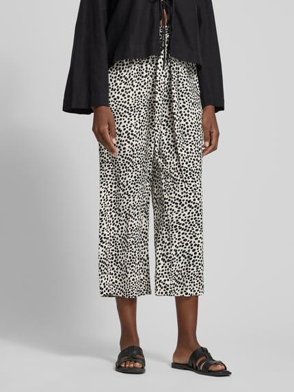 Frauenmodel trägt schwarz-weiß gemusterte Culotte mit Bindegürtel Modell 'JOSA' von Vila, loose Fit, elastischer Bund, Nahaufnahme Unterkörper.
