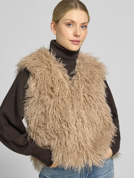 Frauenmodel trägt Weste mit V-Ausschnitt und verdecktem Verschluss von Smith and Soul, beige Faux Fur, gerader Schnitt, Nahaufnahme Oberkörper.