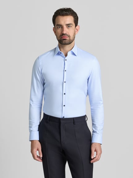 Männermodel trägt Super Slim Fit Business Hemd aus Baumwolle mit Kentkragen von Jake*s, helle Farbe, glatte Textur, Knopfleiste, Ganzkörperansicht von vorne, Rückenlänge 79 cm, Schulterbreite 47 cm, Ärmellänge 68 cm.