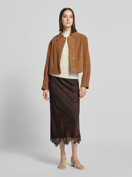 Frauenmodel trägt Midi-Rock mit Spitzenbesatz von VERO MODA, florales Muster, Ausbrenner-Effekt, asymmetrischer Saum, Ganzkörperansicht von vorne.