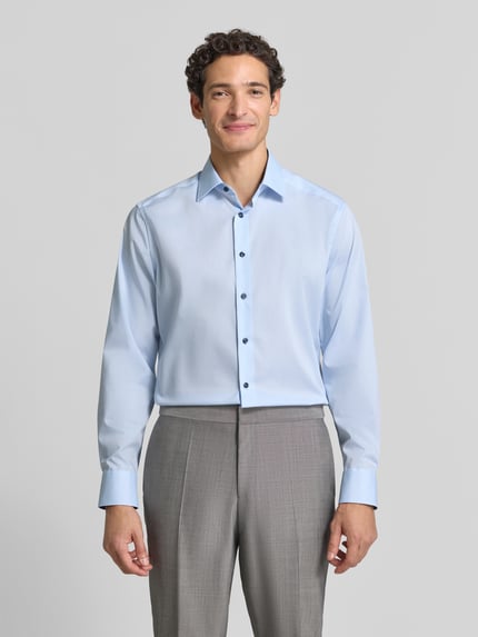 Männermodel trägt ein hellblaues Regular Fit Businesshemd mit Kentkragen von OLYMP, feines Webmuster, Uni-Optik, Ganzkörperansicht von vorne.
