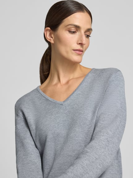 Frauenmodel trägt Regular Fit Sweatshirt aus Viskose-Anteil von Christian Berg Woman in Grau, V-Ausschnitt, Nahaufnahme Oberkörper. Viskose-Mix mit gerippten Abschlüssen, Rückenlänge 63 cm, Ärmellänge 48 cm.