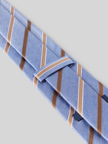 Produktfoto, Krawatte aus reiner Seide von OLYMP mit blauen und beigen Streifen, feine Textur, rechteckige Formen auf grauem Hintergrund