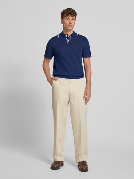 Männermodel trägt dunkelblaues Regular-Fit Poloshirt aus reiner Baumwolle Modell 'JESSE' von Selected Homme, Ganzkörperansicht von vorne. Herren Poloshirt.