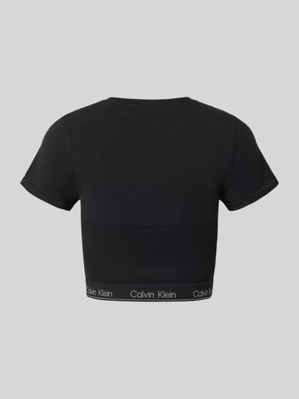 Vrouwenmodel draagt Cropped T-Shirt met Label-Details van Calvin Klein Underwear in zwart, slim fit met elastische logoband, rugaanzicht.