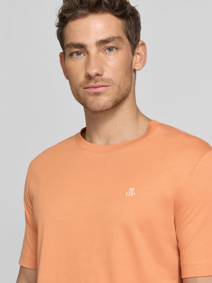 Męski model nosi Regular Fit T-Shirt aus reiner Baumwolle od Marc O'Polo, kolor jednolity, logo, jersey, krótki rękaw, zbliżenie na górę ciała