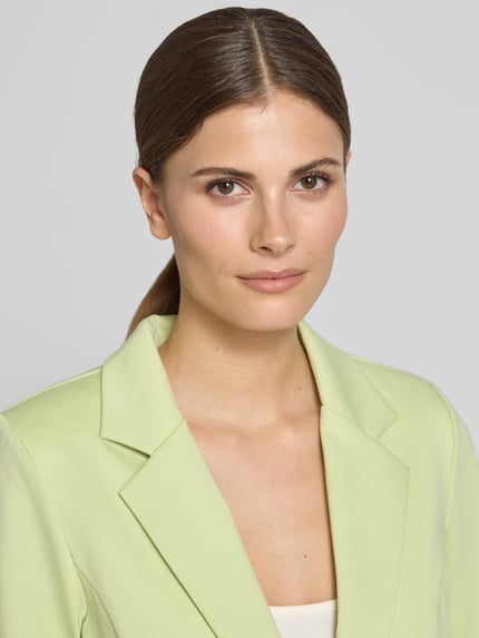 Frauenmodel trägt Regular Fit Blazer mit Viskose-Anteil Modell 'Kate' von ICHI in Hellgrün mit Reverskragen und Paspeltaschen, Nahaufnahme Oberkörper. Rückenlänge 58 cm, Brustweite 43 cm, Ärmellänge 62 cm, Elastischer-Material-Mix.