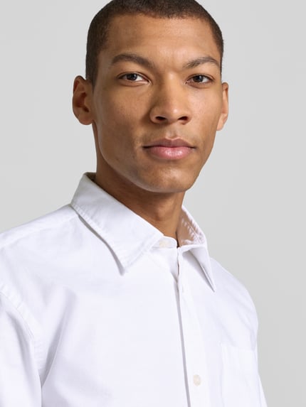 Męski model nosi Relaxed Fit Freizeithemd aus reiner Baumwolle Modell 'OXFORD SHIRT' od SELECTED HOMME, biała, paski, zbliżenie na górną część ciała