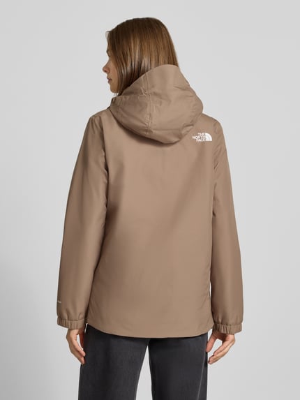 Modelka kobieca nosi Regular Fit Funktionsjacke mit Logo-Print Modell 'Quest Mono' od The North Face w kolorze beżowym, gładka tekstura, kaptur, zamek błyskawiczny, Ganzkörperansicht Rückansicht, kontekst: damska kurtka funkcyjna, długość tyłu w rozmiarze S: 69 cm, szerokość ramion w rozmiarze S: 40 cm, szerokość w rozmiarze S: 40 cm, długość rękawa w rozmiarze S: 63 cm.