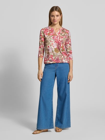 Frauenmodel trägt Regular Fit Bluse aus Viskose-Mix Modell 'Felicity' von Soyaconcept mit Floraler Allover-Print, Halbarm, Tunika-Ausschnitt, Rückenlänge bei Größe S: 63 cm, Ganzkörperansicht von vorne.