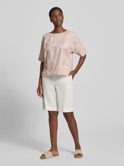 Frauenmodel trägt Blusenshirt aus reiner Baumwolle von Christian Berg Woman im Allover-Look mit Stitchings, Rundhalsausschnitt, Regular-Fit, in sanften Rosatönen, strukturierte Oberfläche, Damen Kurzarmbluse, Rückenlänge 55 cm, Ärmellänge 29 cm, Ganzkörperansicht von vorne.