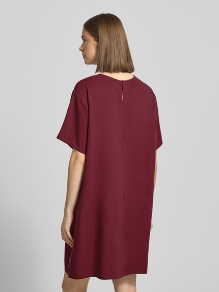 Frauenmodel trägt Figurumspielendes Freizeitkleid aus Lyocell von Marc O'Polo Denim in Optik: Unifarben, Mini-Länge, Materialverarbeitung: Piqué, Ganzkörperansicht Rückansicht.