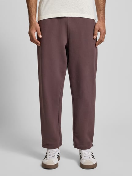 Männermodel trägt Regular Fit Sweatpants mit elastischem Bund Modell 'Source' von BLKVIS aus reiner Baumwolle, 7/8-Länge, Gesäßtasche, Ganzkörperansicht von vorne.