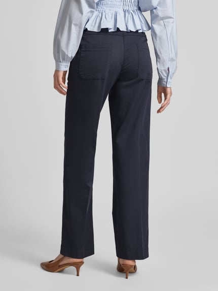 Frauenmodel trägt Chino mit elastischem Bund Modell 'Sue' von TONI aus dunkelblauem Baumwoll-Mix mit Stretch-Anteil, Wide-Fit, Gesäßtaschen, glatte Textur, Ganzkörperansicht Rückansicht.