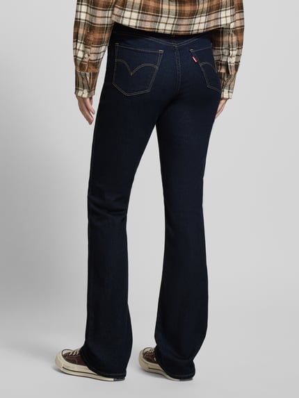 Frauenmodel trägt Bootcut Jeans mit 5-Pocket-Design von Levi's®, dunkelblau, Baumwoll-Mix mit Stretch, Ganzkörperansicht Rückansicht.