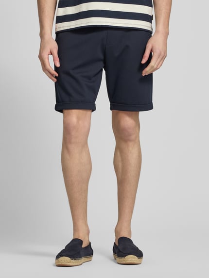 Männermodel trägt Sweatshorts mit elastischem Bund und Gesäßtasche von MCNEAL, dunkelblau, Regular Fit, Nahaufnahme Unterkörper, Vorderansicht.