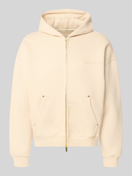 Produktfoto, Sweatjacke mit Kapuze von ANOTHER COTTON LAB in hellem Beige mit Känguru-Tasche, Zwei-Wege-Reißverschluss, gerippte Abschlüsse, lockerer Schnitt, elastischer Baumwoll-Mix, Label-Detail, Vorderseite sichtbar