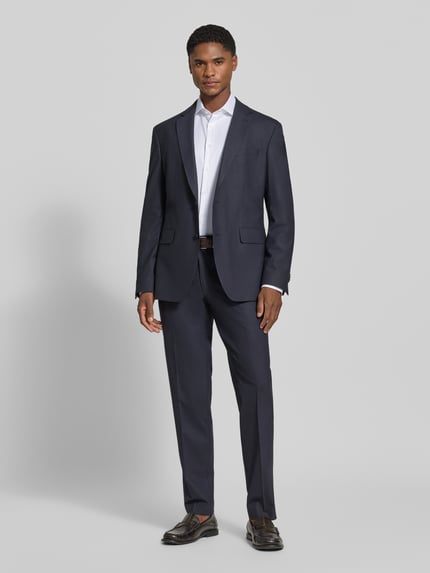 Männermodel trägt dunkelblauen Anzug mit weißem Super Slim Fit Businesshemd in Premiumqualität von Jake*s, Ganzkörperansicht von vorne.